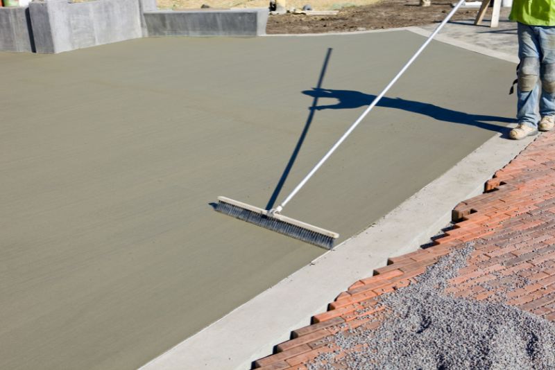 Broom finish being applied to a freshly poured concrete surface