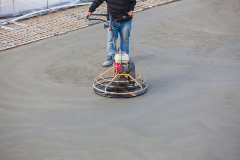 Worker polishing a concrete surface to a smooth finish