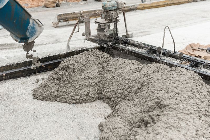 Wet concrete being poured and spread during a slab installation