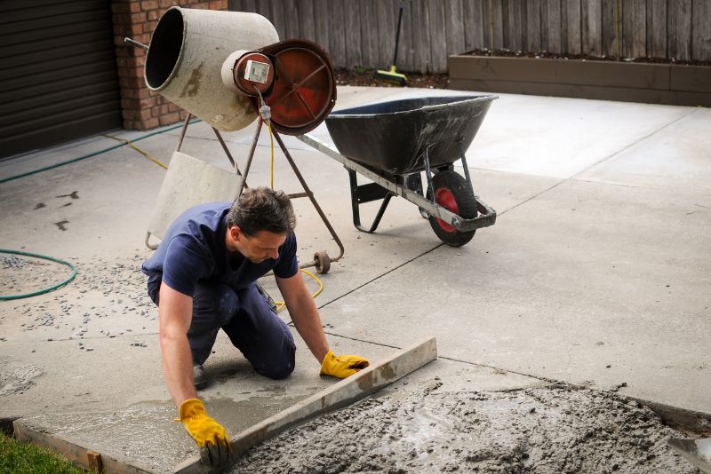 worker repairing a concrete driveway
