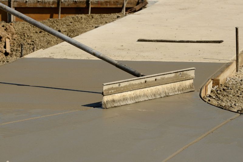 Broom finish being applied to wet concrete for slip resistance