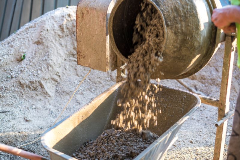 Concrete mixer discharging into a wheelbarrow on site