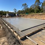 Freshly poured concrete foundation for a new home designed to withstand Queensland's challenging soil conditions