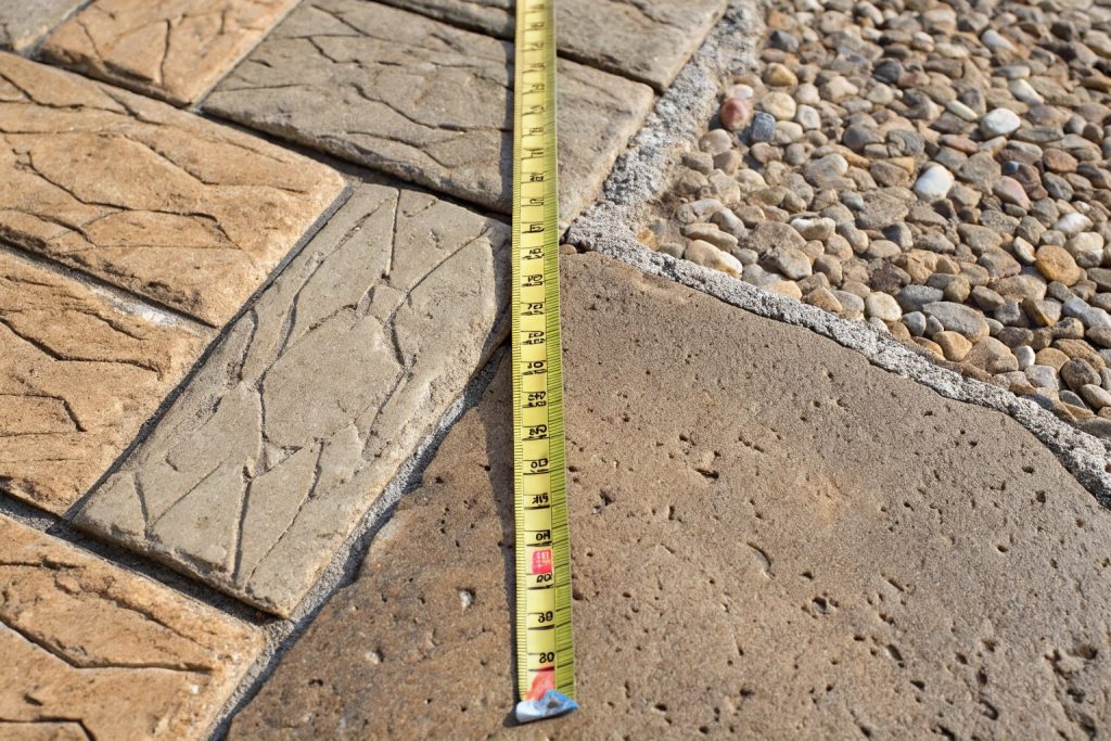 Before and after transformation: Plain cracked concrete replaced with stamped cobblestone pattern increasing Springwood property value