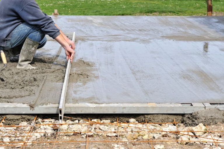 Concreter levelling a freshly poured concrete slab
